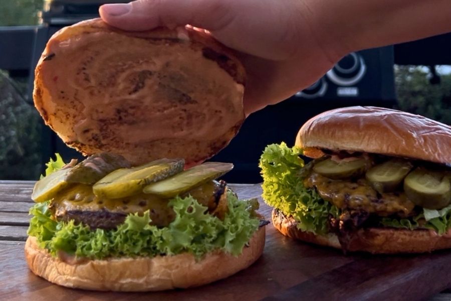 title Gotowy burger z grilla gazowego Broil King - soczysty przekrojony, roztopiony ser cheddar
