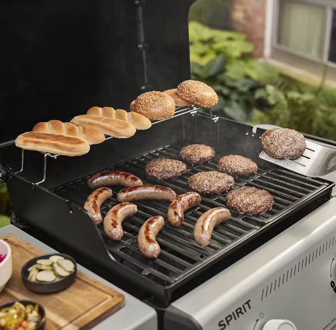 Burgery kiełbasa i pieczywo na ruszcie grilla gazowego jako przykład codziennego grillowania